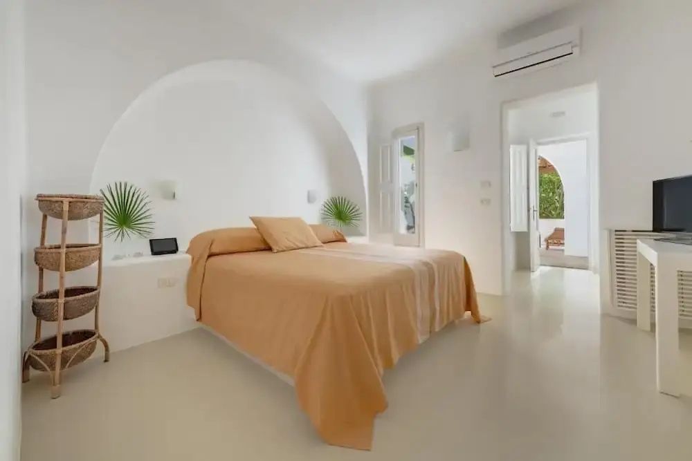 Elegantes, minimalistisch eingerichtetes Doppelzimmer mit weißer Bettwäsche und natürlichen Akzenten.
