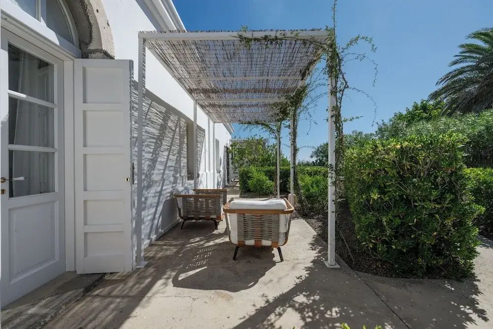 Gartenmöbel auf der Terrasse der Präsidenten Suite unter einer Pergola mit Pflanzen