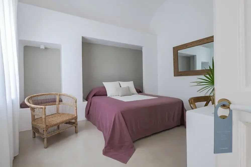 Schön eingerichtetes Zimmer mit Doppelbett und Spiegel