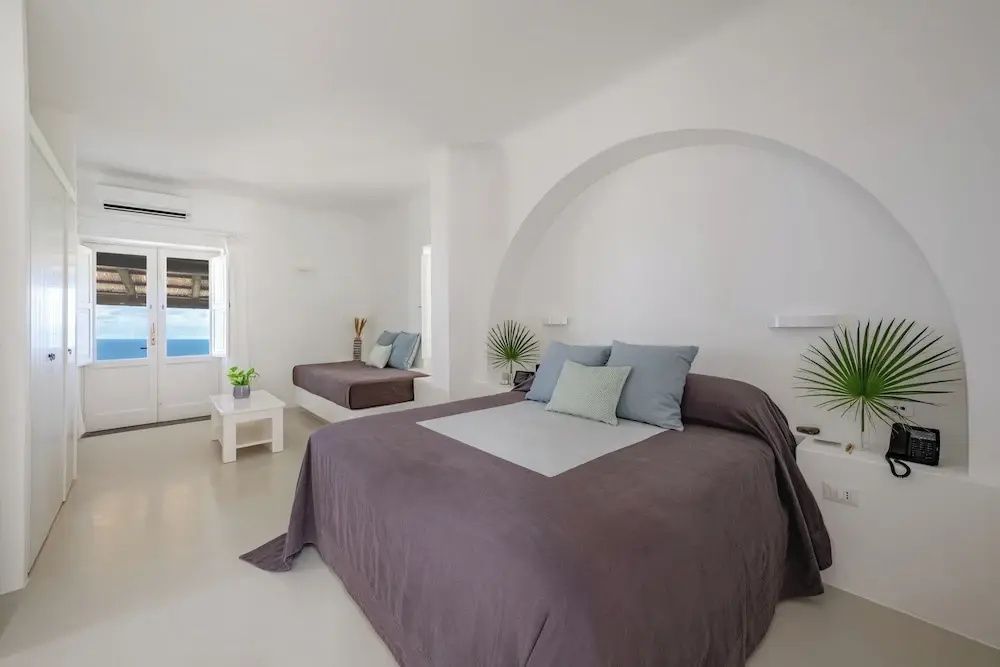 Großzügige Suite mit Doppelbett und Blick auf das Meer aus dem Fenster