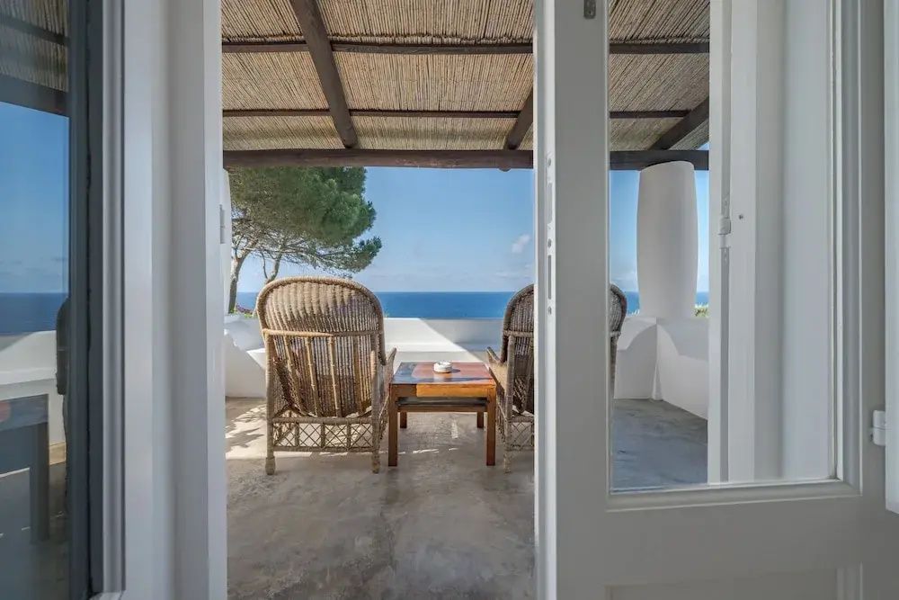 Balkon mit Rattanmöbeln und Blick aufs Meer