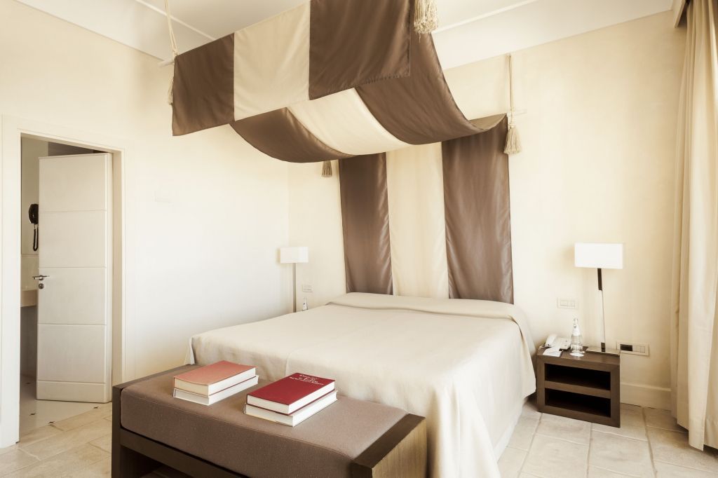 Gemütliches Doppelbett in der Art Sea Side Doppel Suite mit stilvollem Baldachin.
