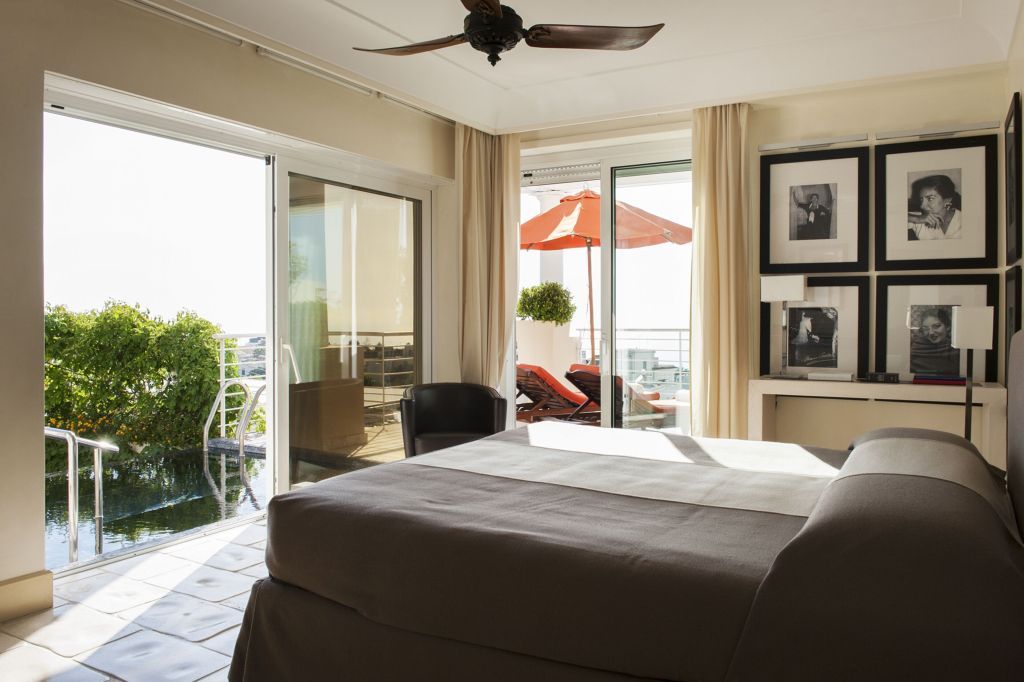 Geräumige Suite mit Doppelbett und Terrasse mit Liegestühlen
