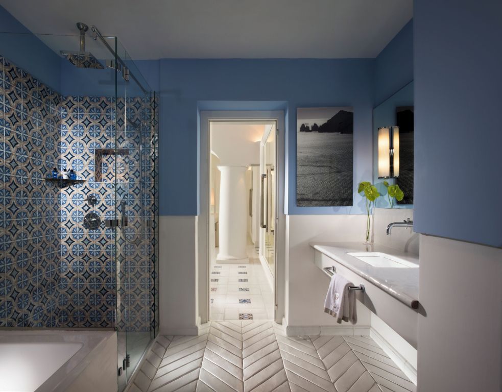 Badezimmer mit stilvollen blauen Fliesen und moderner gläserner Dusche
