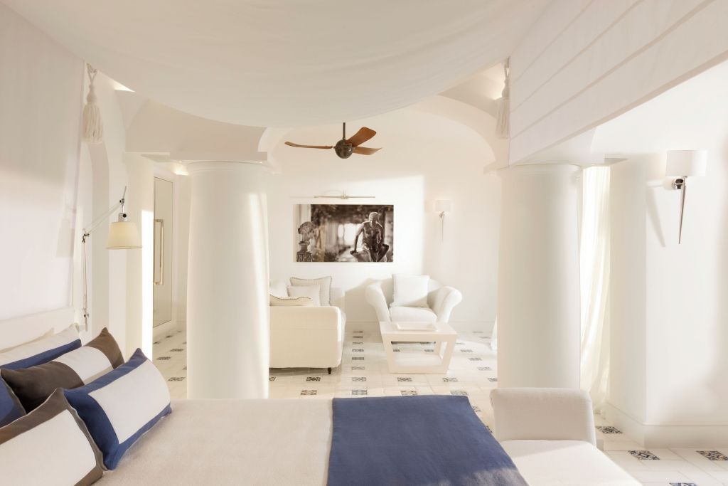 Innenansicht der Suite mit Sofa, weißem Interieur und dekorativem Ventilator