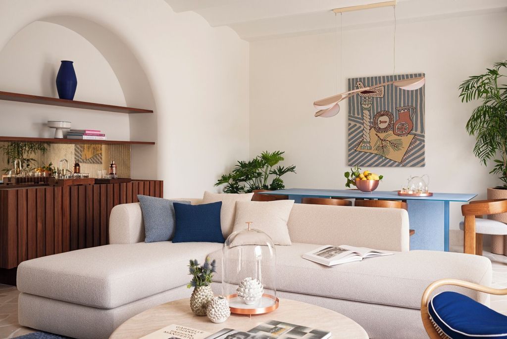 Wohnraum mit elegantem Sofa, Kunstwerk an der Wand und Designobjekten auf dem Tisch