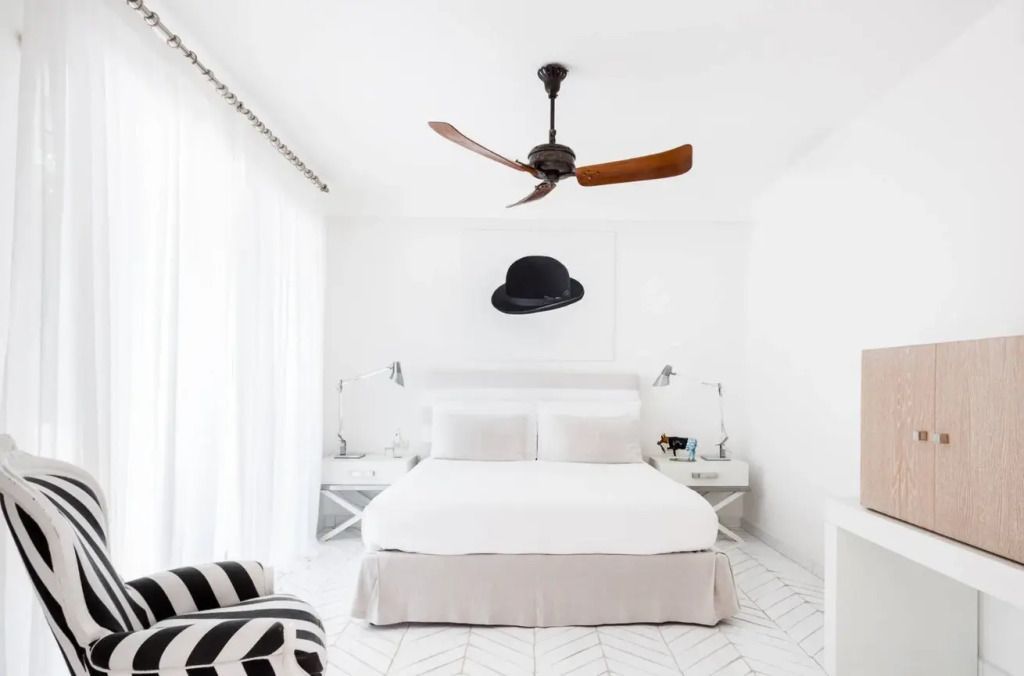 Elegantes Zimmer mit Doppelbett, weißem Dekor und moderner Kunst an der Wand