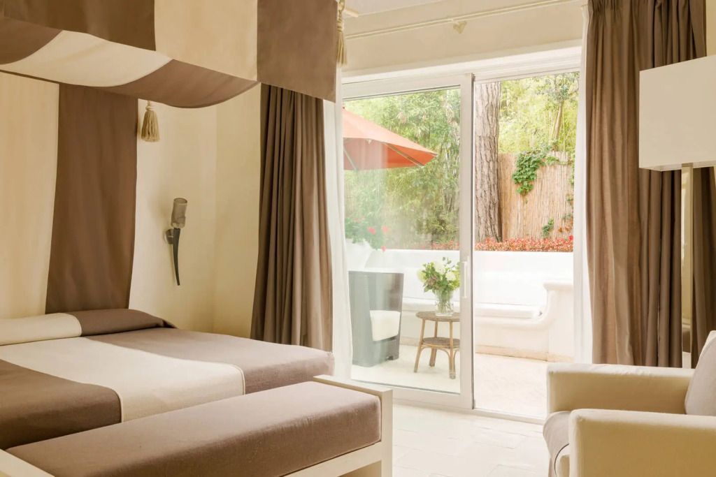 Zweibettzimmer mit Terrasse und Blick in einen grünen Garten