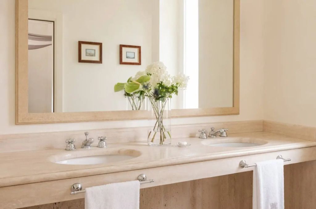 Badezimmer mit Blumenarrangement und großem Spiegel