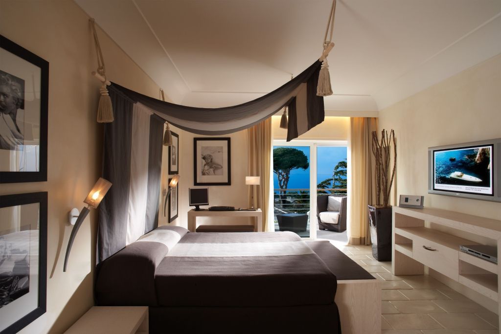 Luxuriöse Suite mit großem Bett und Balkonblick auf das Meer