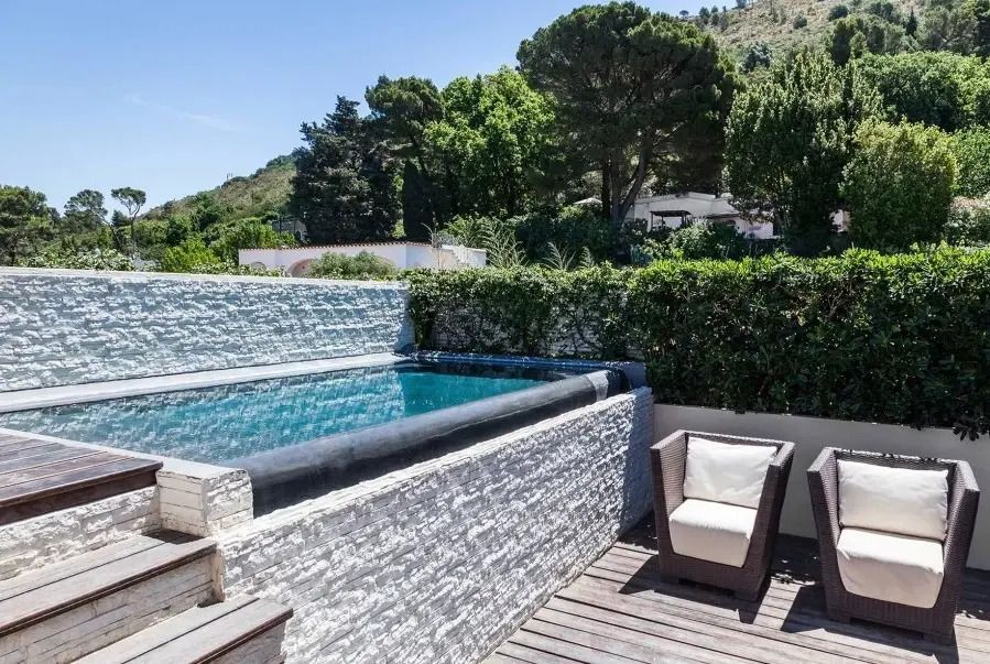 Privater Pool mit Terrasse und grüner Umgebung