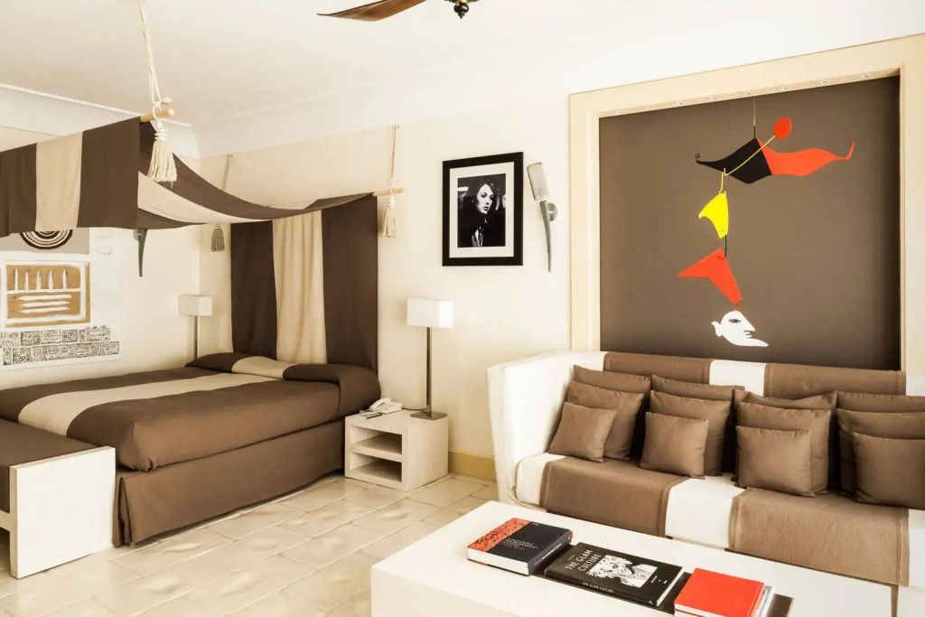 Helles Zimmer mit Doppelbett und moderner Kunst an den Wänden