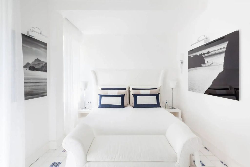 Helles Doppelzimmer mit weißem Interieur und dekorativen Kissen