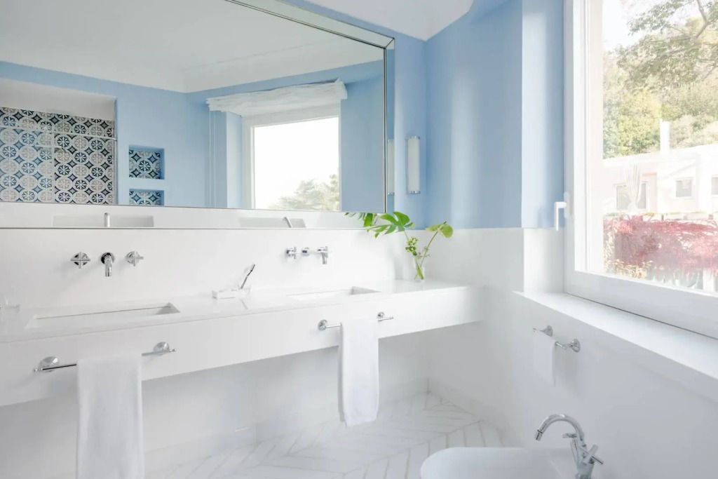 Modernes Badezimmer mit großem Spiegel und blauen Wänden