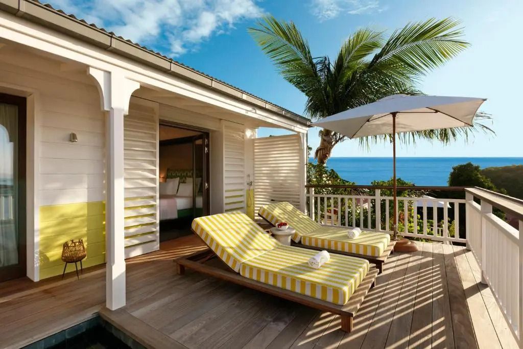 Terrasse mit Meerblick und Sonnenliegen in der Deluxe Suite des Hotels.