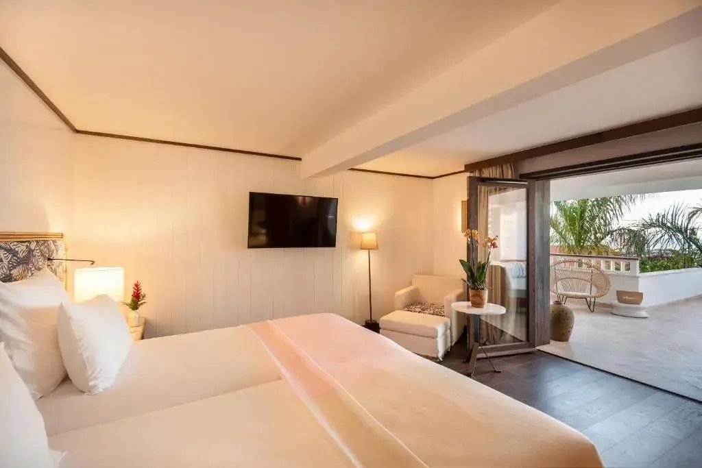 Helles Deluxe Zimmer mit gemütlichem Doppelbett und Balkon mit Meerblick