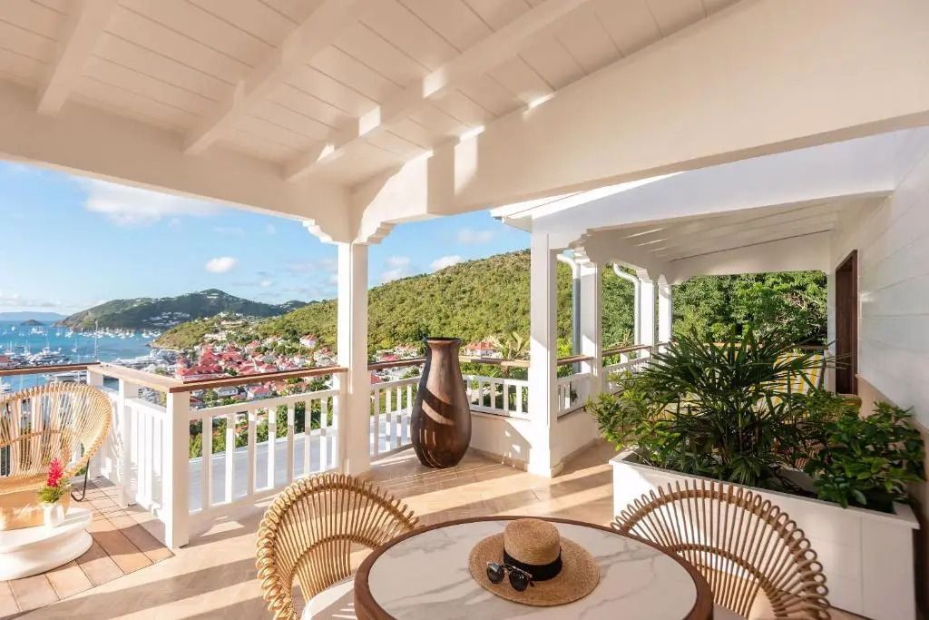 Geräumige Terrasse mit Sitzbereich und Panoramablick auf grüne Hügel und Meer