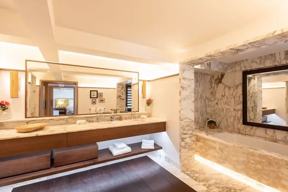 Luxuriöses Badezimmer mit stilvollem Marmor und großem Spiegel.