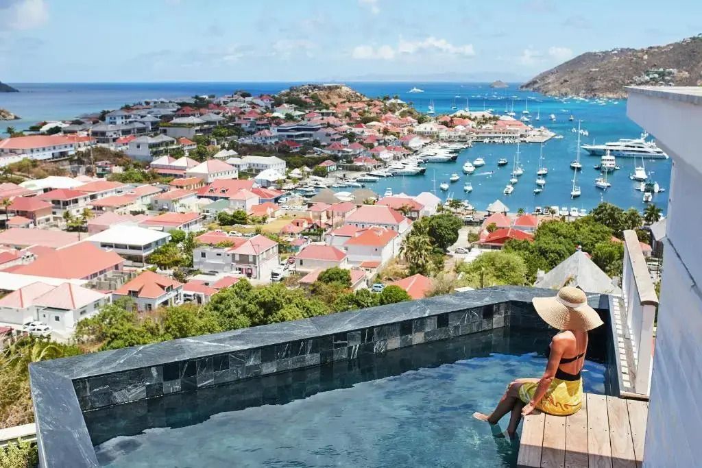 Infinity Pool mit Blick auf malerische Küstenstadt und das Meer