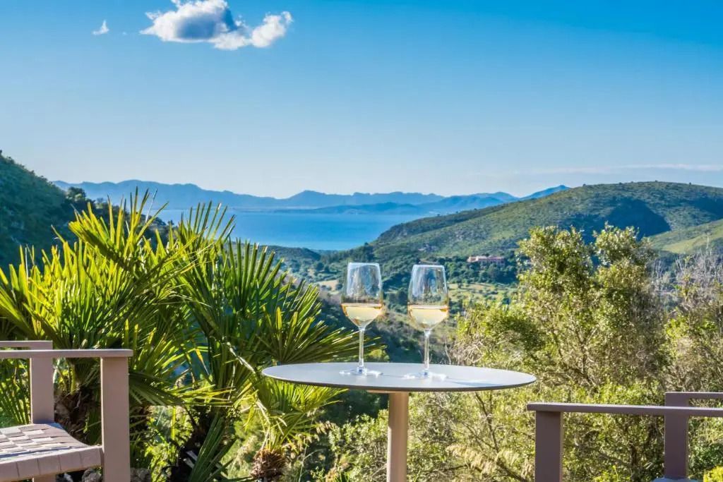 Atemberaubender Meerblick von der Terrasse eines Hotels mit zwei Gläsern Wein