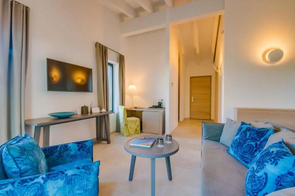 Moderner Wohnbereich einer Suite mit Sitzgelegenheiten und Fernseher