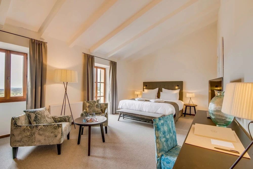 Geräumiges Deluxe Zimmer mit Doppelbett und stilvoller Sitzecke