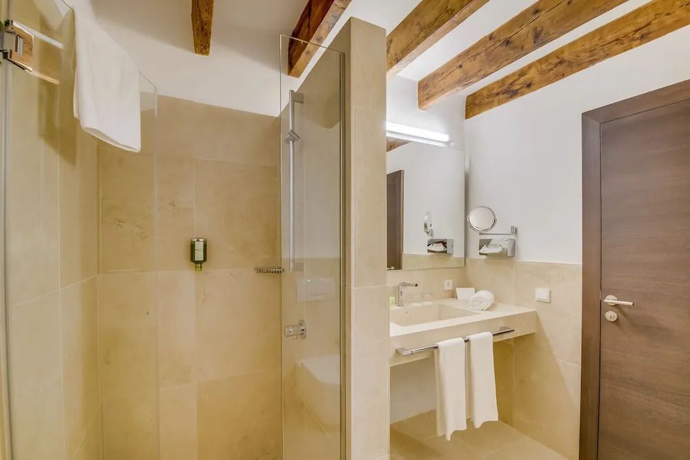 Modernes Badezimmer mit Dusche, Waschbecken und Holzbalken