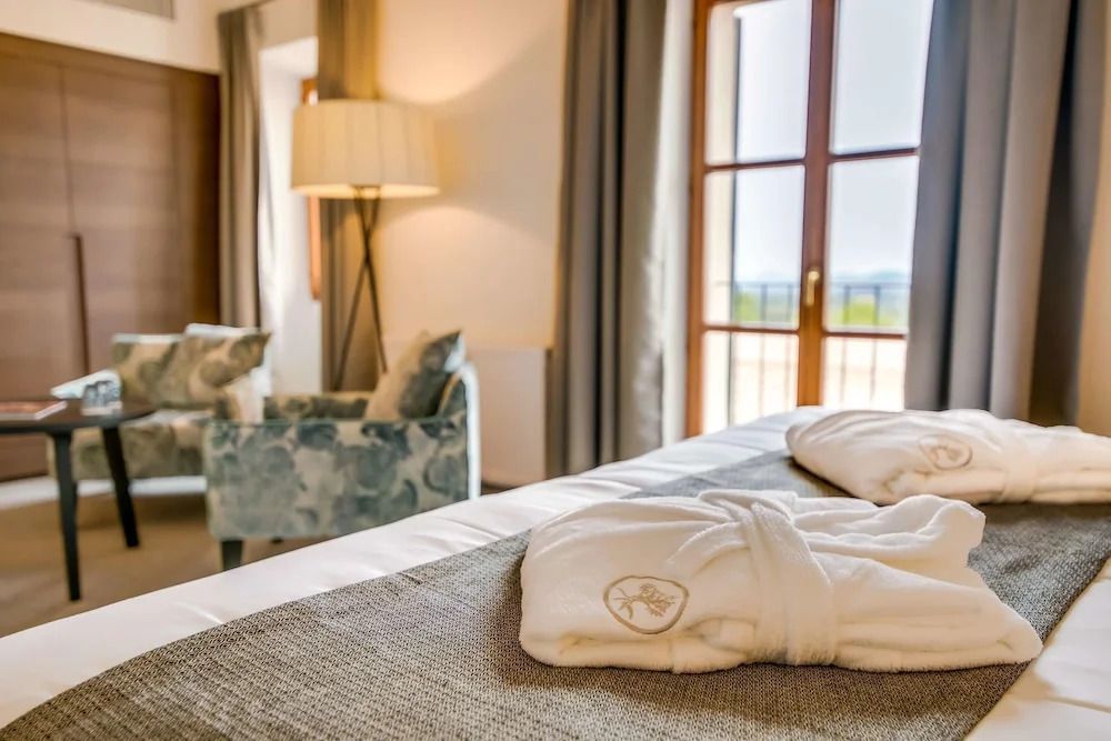 Nahaufnahme eines Betts mit Bademänteln im Deluxe Zimmer