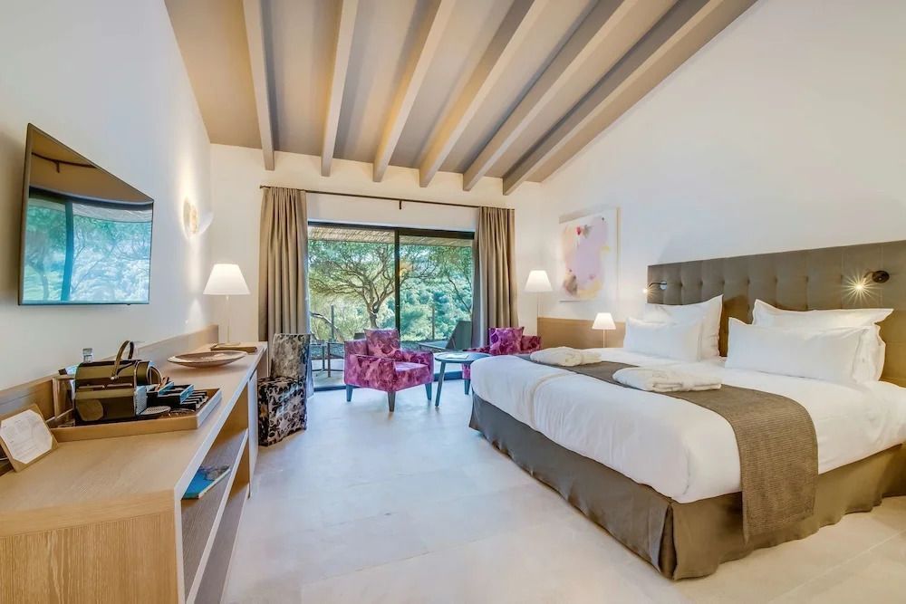 Helles Hotelzimmer mit Doppelbett und Terrassenblick