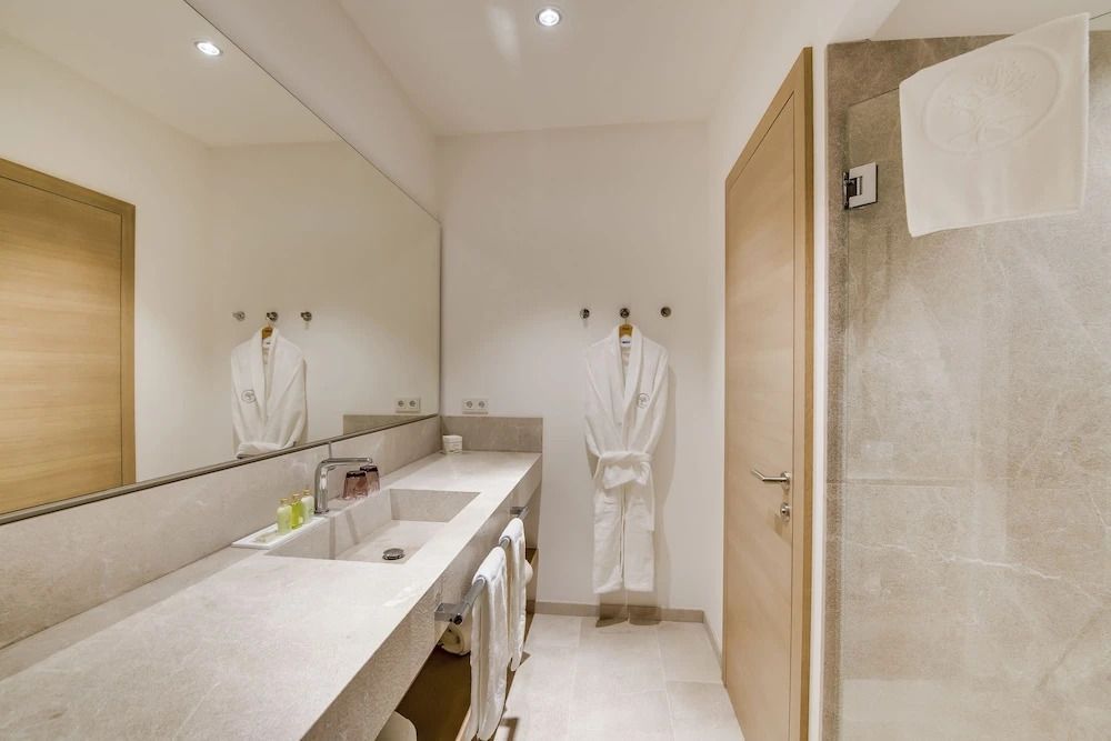 Modernes Badezimmer mit großem Spiegel und weißem Bademantel