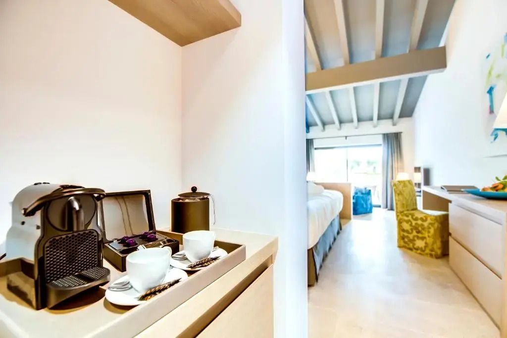 Helle Junior-Suite mit Blick auf bequeme Betten und Kaffeemaschine