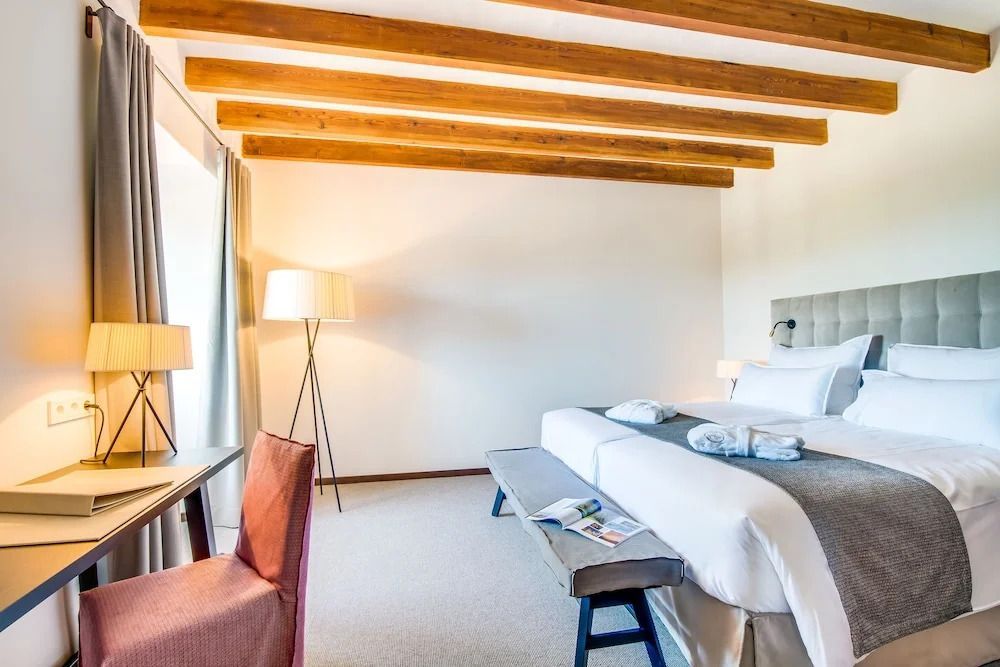 Schlafbereich der Klassisch Suite mit Doppelbett und Holzbalken