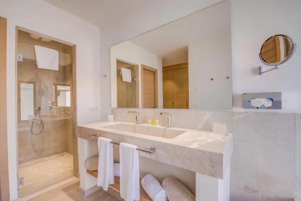 Geräumiges Badezimmer mit Doppelwaschbecken und eleganter Steinverkleidung