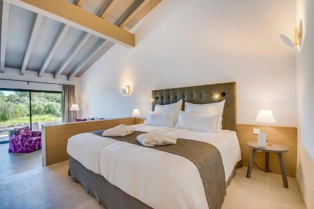 Geräumiges Doppelbett mit eleganten Kissen in der Superior Suite des Carrossa Hotel & Spa.
