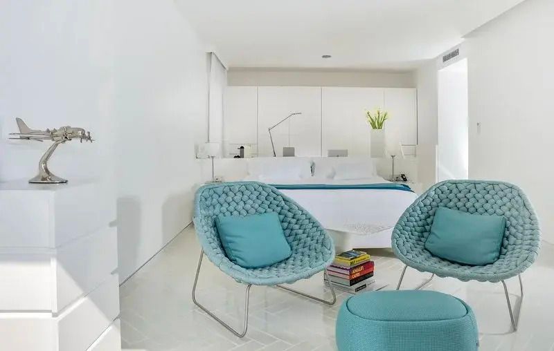 Elegantes Schlafzimmer mit weißen Wänden und türkisfarbenen Akzenten