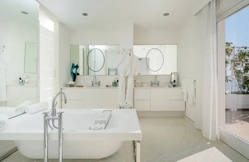 Geräumiges Badezimmer mit doppelten Waschbecken und freistehender Badewanne