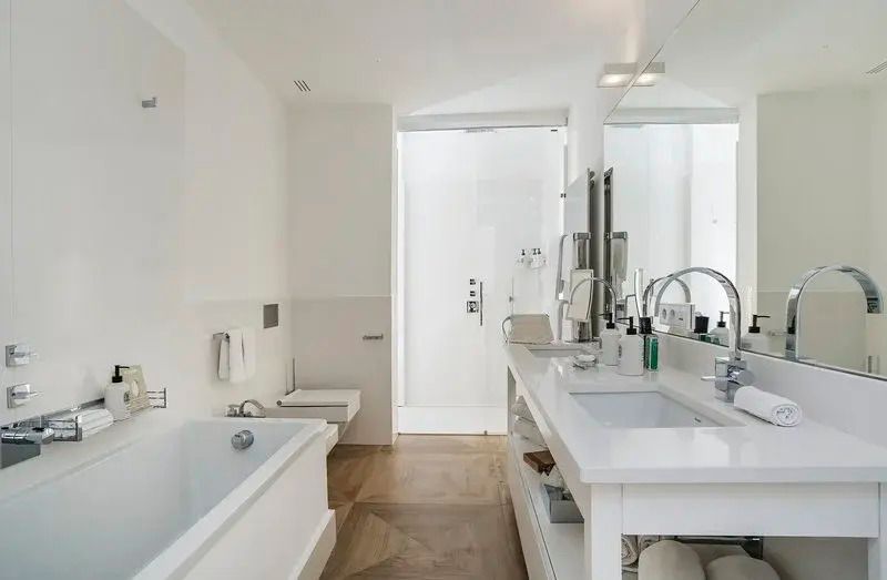 Stilvolles Badezimmer mit Badewanne und Doppelwaschbecken in heller Umgebung.