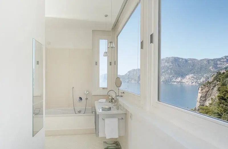 Luxuriöses Badezimmer mit großem Fenster und Meeresblick im Casa Angelina