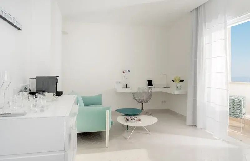 Gemütliche Sitzecke in einem eleganten Hotelzimmer mit Schreibtisch und Pastellfarben