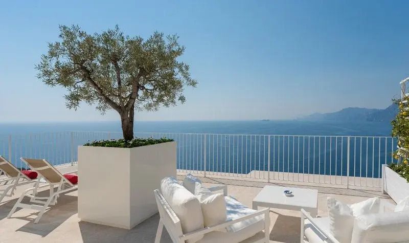 Terrasse mit Olivenbaum und Sitzbereich vor dem Meer