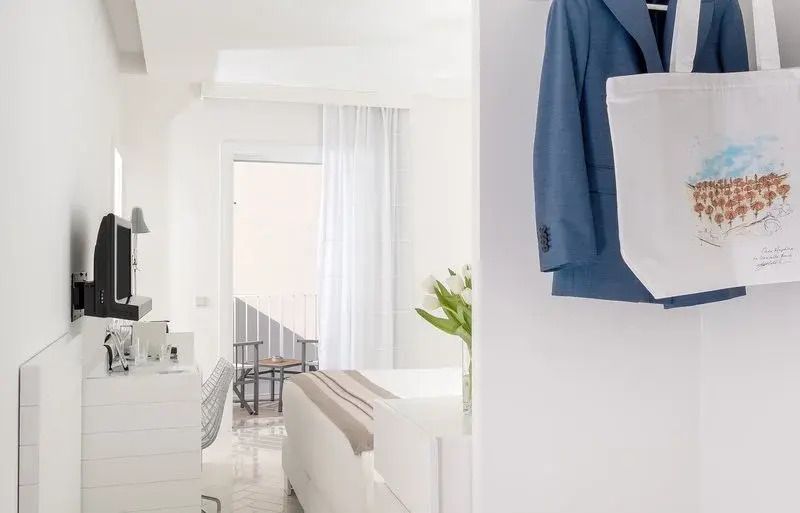 Elegantes Zimmer mit Arbeitsplatz, frischen Blumen und Blick auf den Balkon