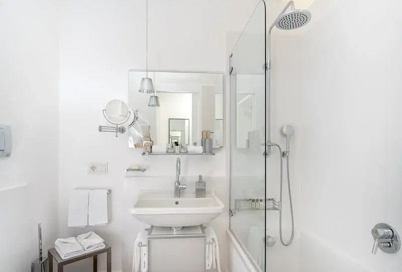 Modernes Badezimmer mit Glasduschwand und heller Einrichtung.