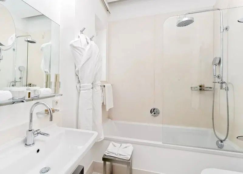 Helles Badezimmer mit Dusche und großem Spiegel