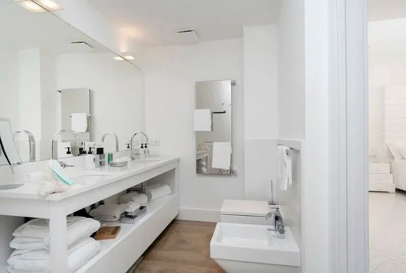Badezimmer mit großem Spiegel und modernen Annehmlichkeiten