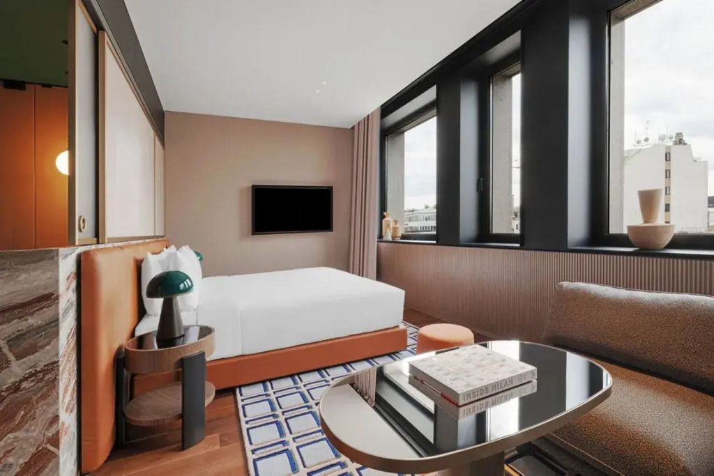 Helles Zimmer mit großem Bett, modernen Möbeln und großen Fenstern