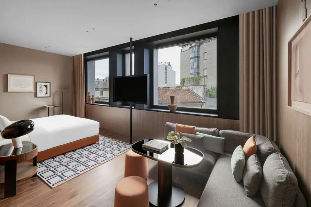 Geräumiges Zimmer mit Doppelbett, großem Fenster und gemütlicher Sitzecke