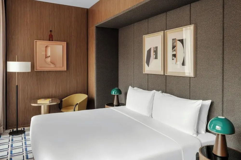 Gemütliches Hotelzimmer mit Doppelbett, stilvoller Beleuchtung und Kunstwerken an der Wand