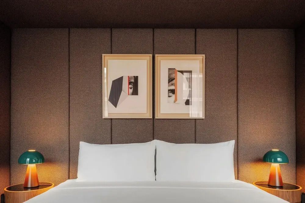 Frontalansicht des Doppelbettes in einem stilvoll eingerichteten Hotelzimmer