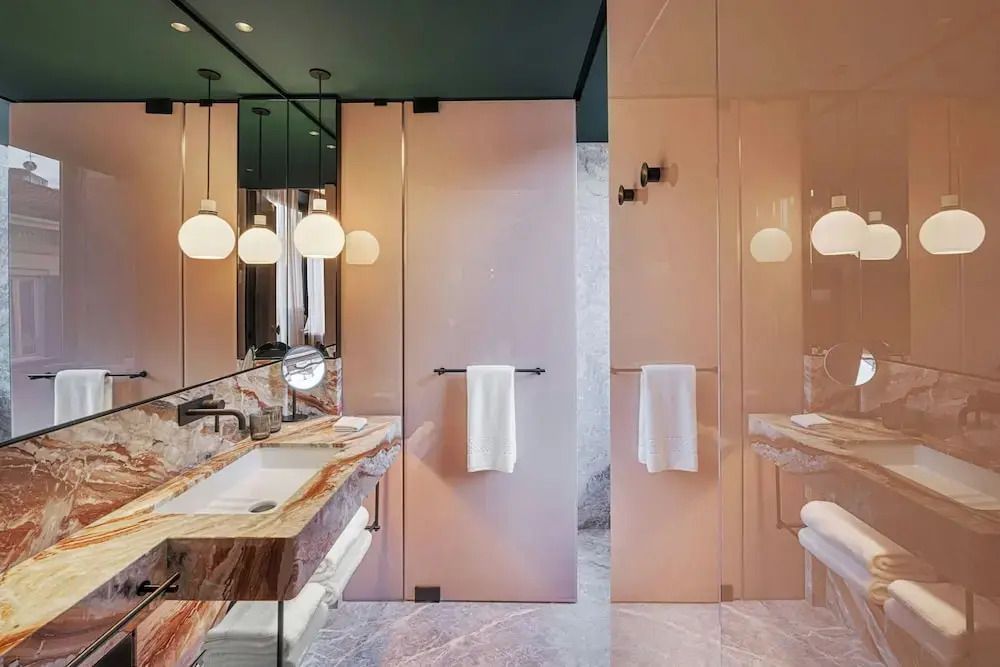 Moderner Hotelbadezimmerbereich mit Design-Waschbecken und eleganter Beleuchtung