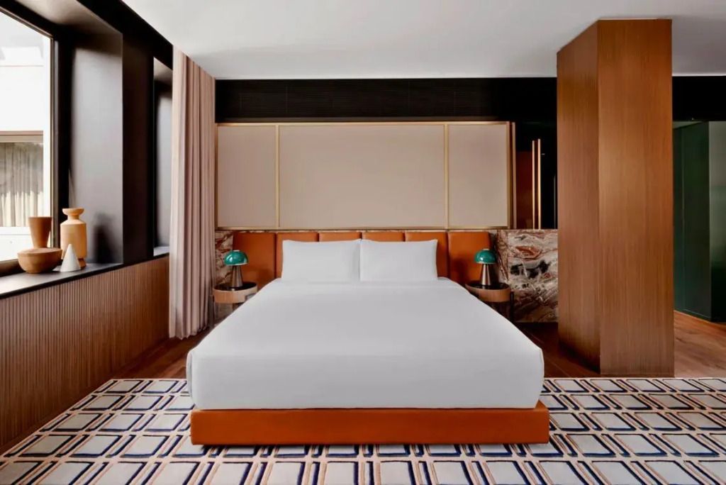 Moderne und elegante Suite mit großem Doppelbett, stilvollen Möbeln und warmen Farbtönen.